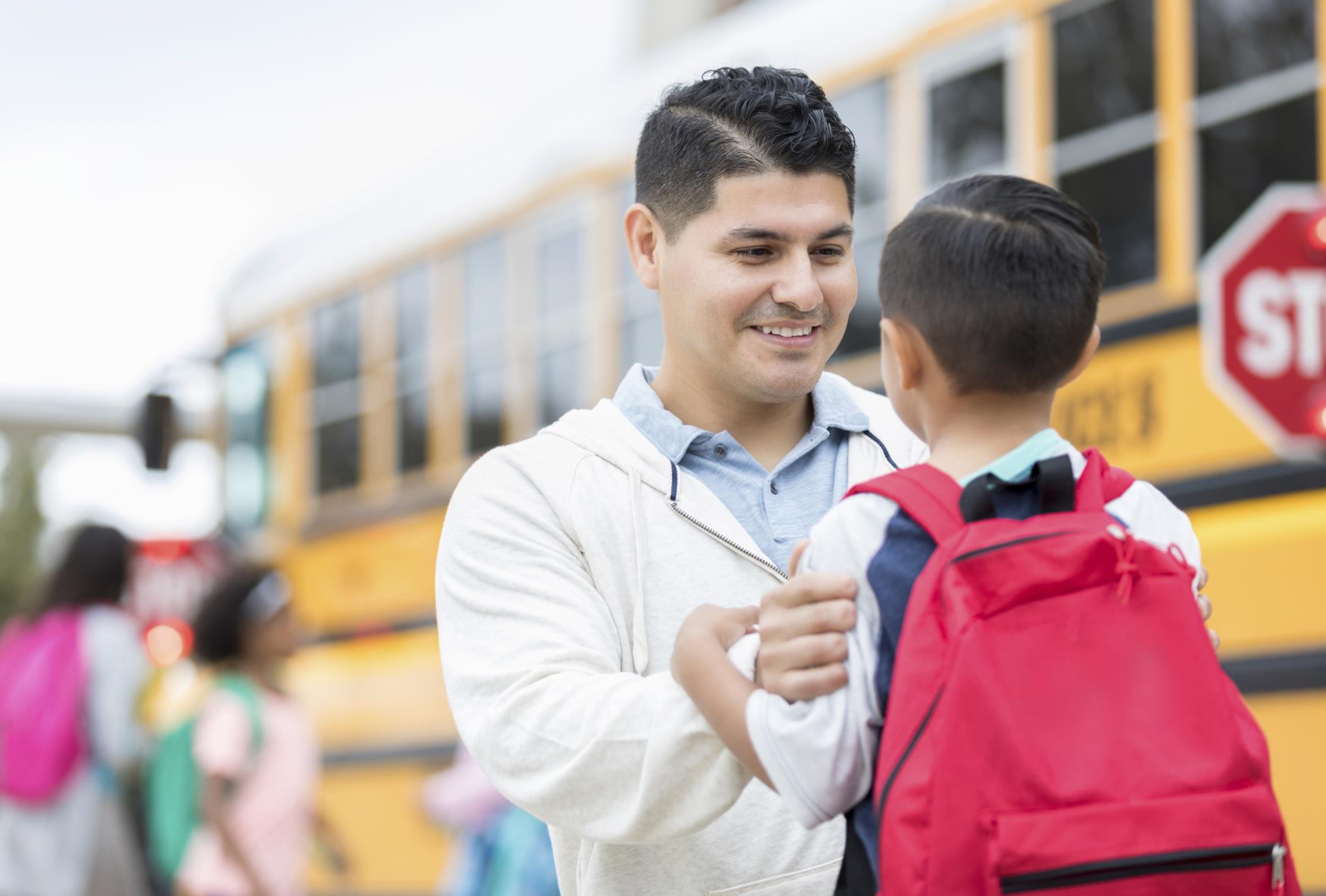 Caregiver with child getting ready to ride the school bus