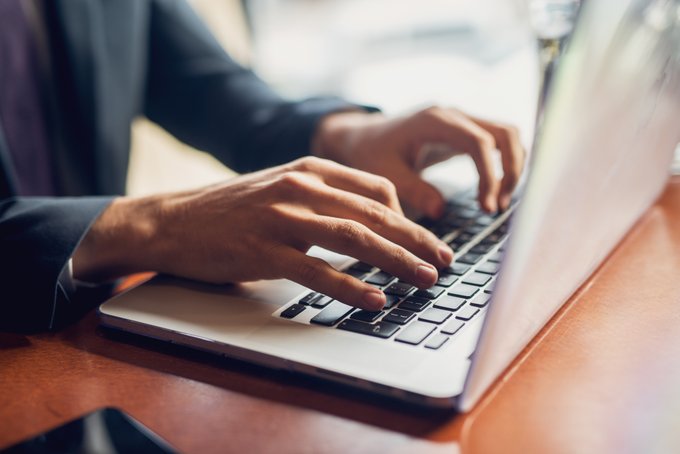 hands typing on a laptop