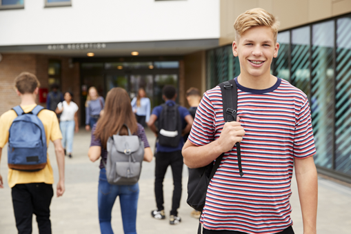 middle school student standing in front of school building