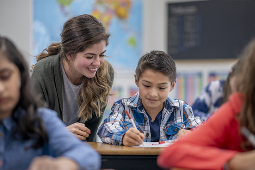 teacher helping a student at their desk