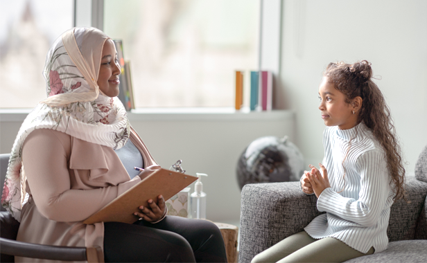 A picture of a counselor and a student having a conversation.