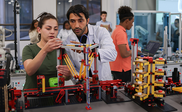 Teacher and Student work on a robotics project together.