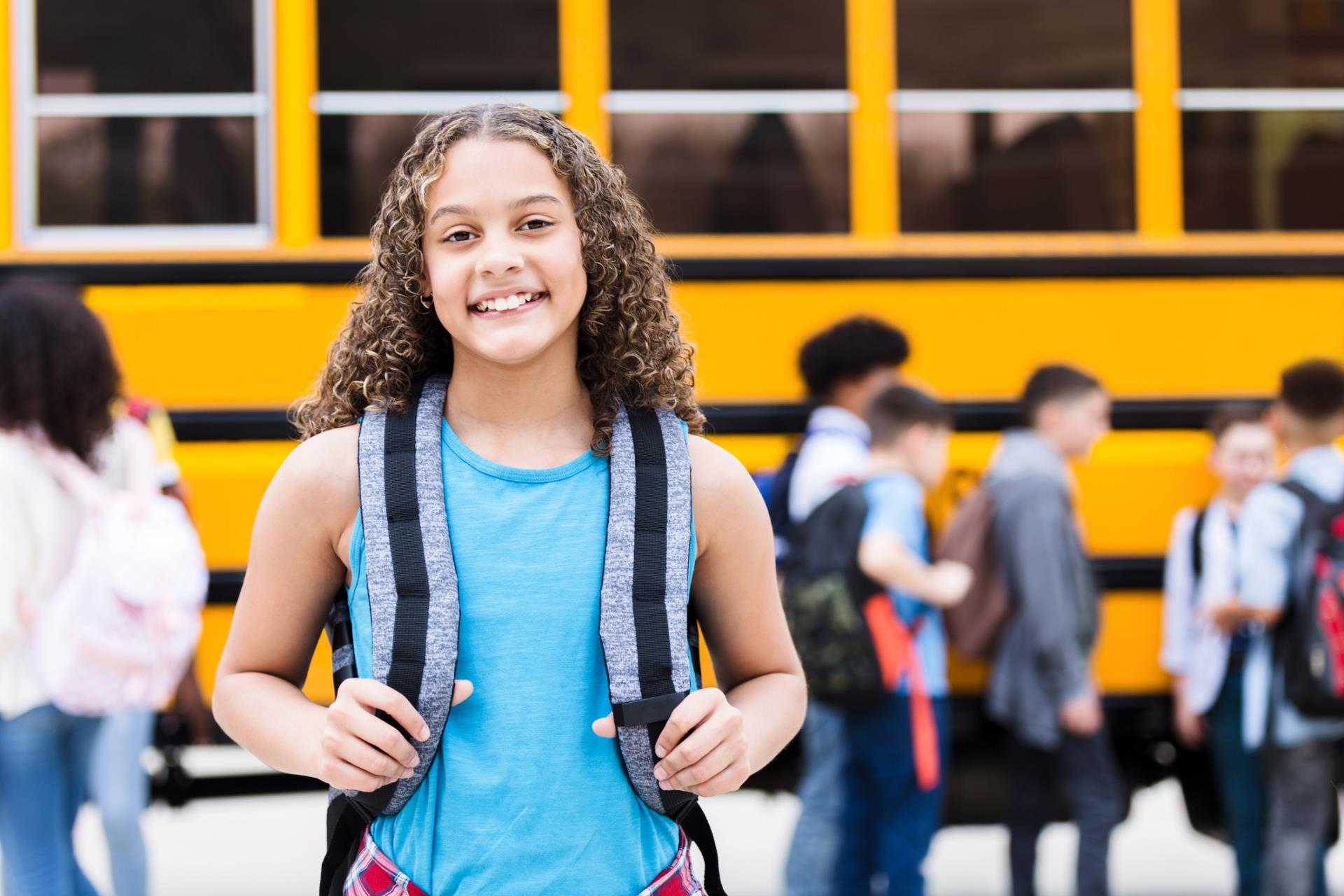 Student smiles before getting on the school bus.