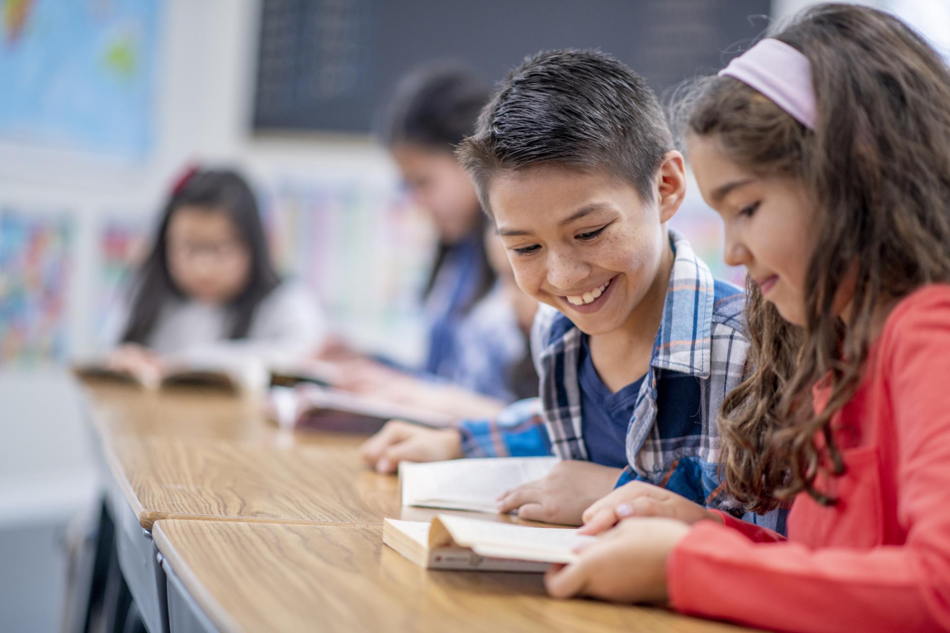 Upper elementary students reading a chapter book together.