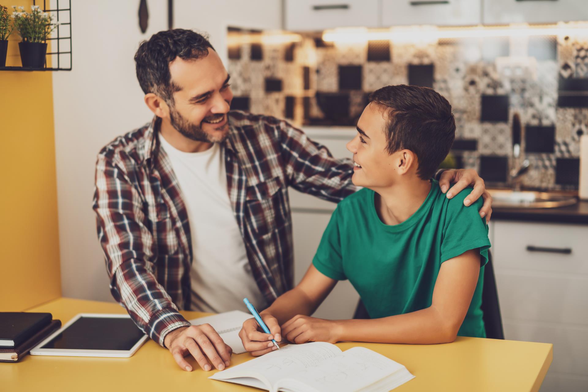 Parent talks to teen at dinner table.