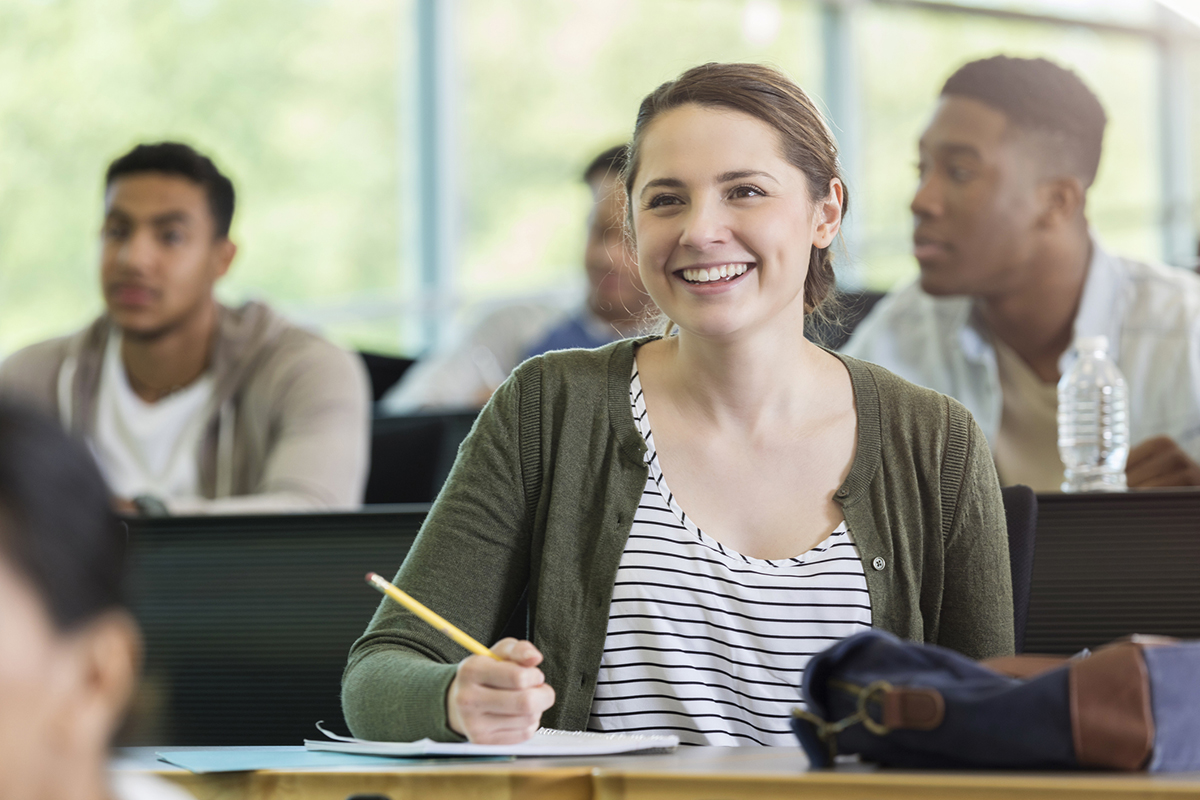 Adult student takes notes during class.