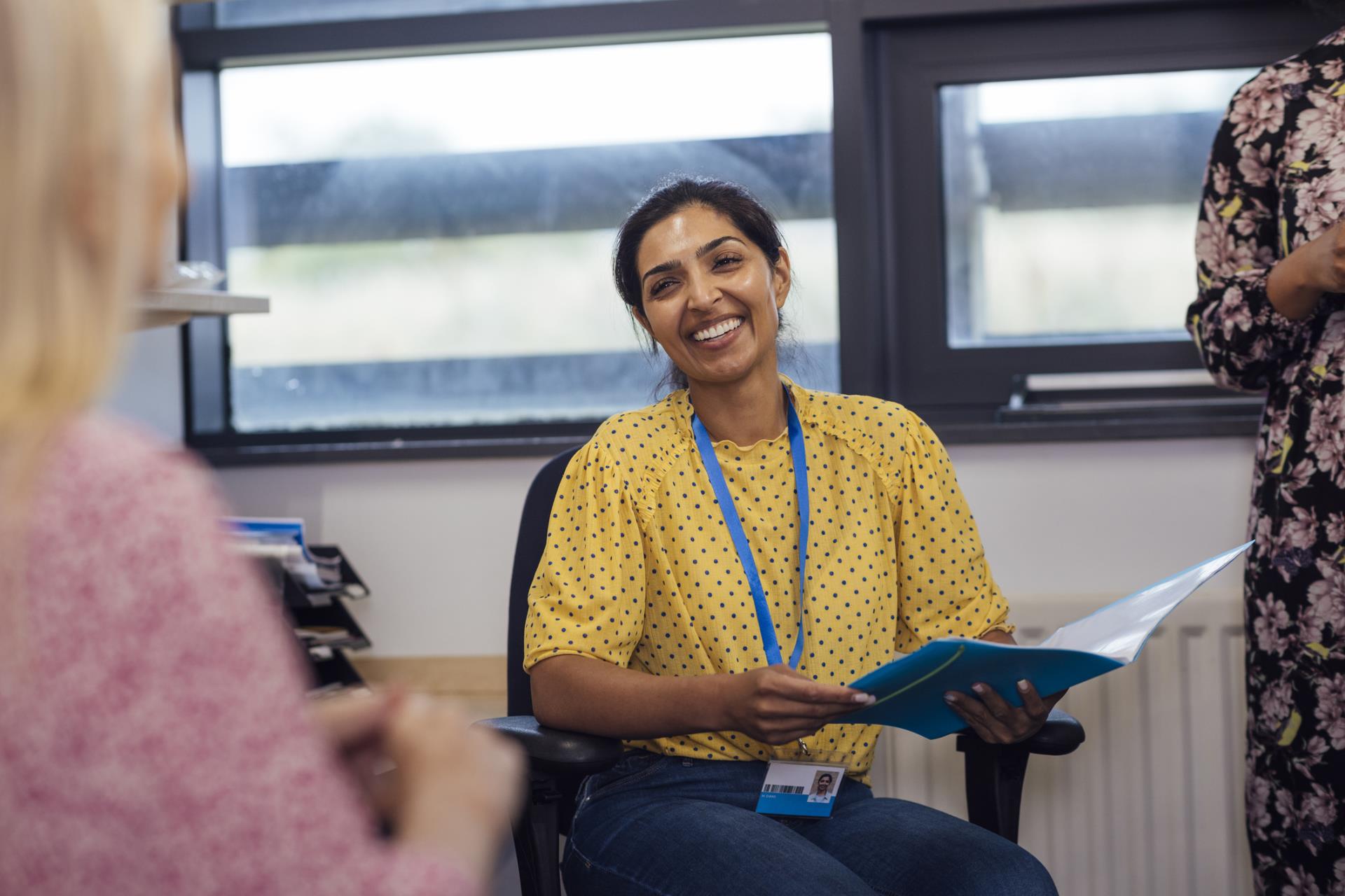 teacher smiling with folder