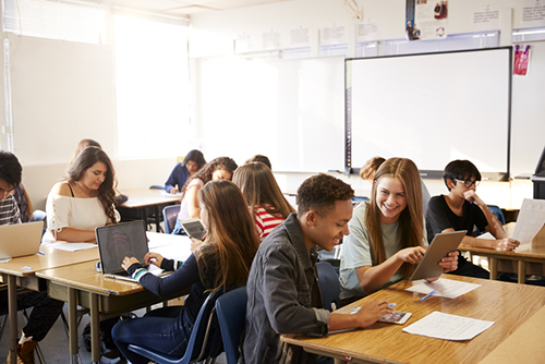 high school students working on laptops